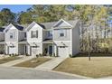 Three-story townhomes with gray siding, attached garages, and landscaping at 128 Buchanan Cir, Goose Creek, SC 29445