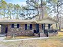 Brick ranch house with a covered porch, dark shutters, and a landscaped yard at 1401 Rivers St, Walterboro, SC 29488