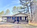 Brick ranch house with a covered porch, dark shutters, and a landscaped yard at 1401 Rivers St, Walterboro, SC 29488