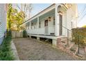 White cottage with a spacious front porch, brick pathway, and a fenced yard at 17 H St, Charleston, SC 29403