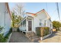 White cottage with a front porch, brick pathway, and mature trees at 17 H St, Charleston, SC 29403