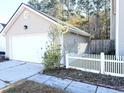 Attached garage with white door and a white picket fence at 207 Moon Dance Ln, Summerville, SC 29483