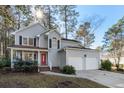 Two-story house with gray siding, two-car garage, and landscaped yard at 1045 Shinnecock Hills Ct, Summerville, SC 29483