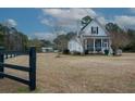 White house with black fence and spacious yard at 1104 Hitchfield Ln, Awendaw, SC 29429