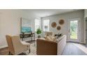 Living room with a brown sofa, two armchairs, and access to a backyard at 135 River Hill Rd, Goose Creek, SC 29445