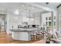 Modern kitchen with white cabinets, large island, and hardwood floors at 1484 Old Rosebud Trl, Awendaw, SC 29429