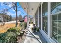 Covered porch with white railings and American flag at 211 Brailsford Rd, Summerville, SC 29485