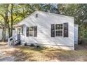 Side view of a renovated light gray house with black shutters and a small porch at 2720 W Surrey Dr, North Charleston, SC 29405