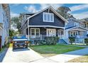 Exterior view of charming dark-painted home with front porch at 33 Cypress St, Charleston, SC 29403