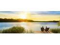 Couple relaxing on chairs by the lake at sunset at 334 Hillman Trail Dr, Moncks Corner, SC 29461
