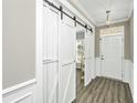 Bright entryway with white shiplap barn doors opening to another room and a view of hardwood floors at 394 Sanctuary Park Dr, Summerville, SC 29486