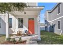 Front porch with coral door and seating area at 3955 Four Poles Park Dr, North Charleston, SC 29405