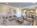 Open living room showcasing a sectional sofa, coffee table, and view into the kitchen and dining area at 470 White Magnolia St, Moncks Corner, SC 29461