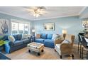 Living room with blue sofas, wicker chair, and coastal decor at 9000 Palmetto Dr # 103C, Isle of Palms, SC 29451