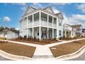 Two-story light teal house with white accents, front porch, and landscaped yard at 229 Symphony Ave, Summerville, SC 29486