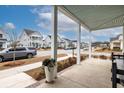 Covered front porch with seating area overlooking a tree-lined street at 229 Symphony Ave, Summerville, SC 29486