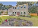 Two-story house with neutral siding, landscaping, and a wood fence at 602 Leaning Pin Ct, Summerville, SC 29485