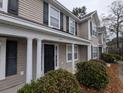 Two-story tan house with white columns, black door, and landscaping at 8875 Jenny Lind St, North Charleston, SC 29406