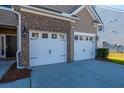 Two-car garage with white doors and brick facade at 9930 Winged Elm St, Ladson, SC 29456