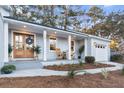 Updated home with light gray exterior, new front door, and rocking chairs on the porch at 1109 Calm Water Ct, Mount Pleasant, SC 29464