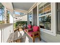 Front porch with red cushioned chairs and a wooden bench at 123 Beam St, Huger, SC 29450