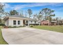 Ranch style home with a large concrete driveway and mature landscaping at 1331 Saint Clair Dr, Charleston, SC 29407