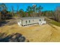 Rear view of a manufactured home showcasing its deck and woodland setting at 240 Carolina Dr, Saint Stephen, SC 29479