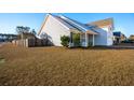 Side view of the house showcasing the yard and wooden fence at 3026 Gulfstream Ln, Ridgeville, SC 29472