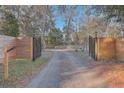 Long driveway with wooden gates leading to home at 3980 River Rd, Johns Island, SC 29455