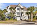 Two-story home with a charming facade, landscaping, and a spacious driveway at 65 Ocean Point Dr, Isle of Palms, SC 29451