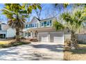 Two-story house with green shutters, palm trees, and a two-car garage at 174 Winding Rock Rd, Goose Creek, SC 29445