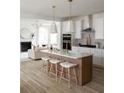Modern kitchen featuring island, white cabinets, and hardwood floors at 323 Abercom Place Dr, Moncks Corner, SC 29461