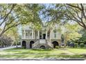Two story house with a large front porch, palm trees, and manicured lawn at 400 Bay Crossing Rd, Mount Pleasant, SC 29464