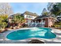Kidney-shaped pool with brick deck and fire pit at 4245 Club Course Dr, North Charleston, SC 29420