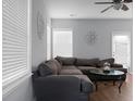 Spacious living room with gray sectional sofa, hardwood floors, and ceiling fan at 563 Alderly Dr, Moncks Corner, SC 29461