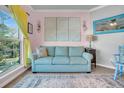 Relaxing living area with a light teal sofa and large windows offering natural light at 700 Daniel Ellis Dr # 2201, Charleston, SC 29412