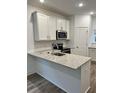 Modern kitchen with white cabinets, granite countertops, and stainless steel appliances at 107 Aplomb Alley # 13, Charleston, SC 29414