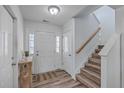Bright entryway with wood-look floors, white door and staircase at 111 Brittondale Rd, Summerville, SC 29485