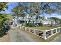 Charming home with a spacious front yard, large tree, and white fence at 186 Sans Souci St, Charleston, SC 29403