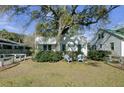 Charming home with a spacious front yard, large tree, and white fence at 186 Sans Souci St, Charleston, SC 29403