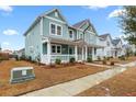Two-story house with light teal siding, a porch, and landscaping at 312 Parish Farms Dr, Summerville, SC 29486
