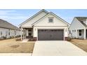 Two-car garage and front porch. White siding and brick accents at 333 Dahlia Row Dr, Summerville, SC 29486