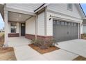Covered front porch with brick columns and a dark door at 333 Dahlia Row Dr, Summerville, SC 29486