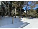 Fenced backyard with mature trees and snowy ground at 613 Pompano St, Edisto Island, SC 29438