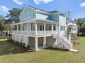 Two-story house with light blue siding, white trim, and a wrap-around porch at 6522 Beagle Club Rd, Meggett, SC 29449