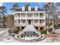 Two story home with brick and siding, large front porch and landscaping at 7003 Old Landing Dr, Hanahan, SC 29410
