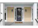 Elegant black front door with sidelights and a welcoming porch at 7003 Old Landing Dr, Hanahan, SC 29410
