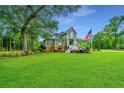Two story home with a large front yard, palm trees, and American flag at 975 Mayfield St, Summerville, SC 29485