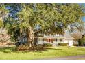 Brick home with a red door, large oak tree, and spacious yard at 1219 Edward Dr, Moncks Corner, SC 29461