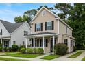 Tan two-story house with black shutters, a front porch, and landscaping at 1762 Bee Balm Rd, Johns Island, SC 29455